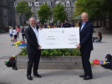 Bobby Anderson (Left) presenting chairman Graham Thom (Right) with cheque at Walker Road Primary school in Torry.