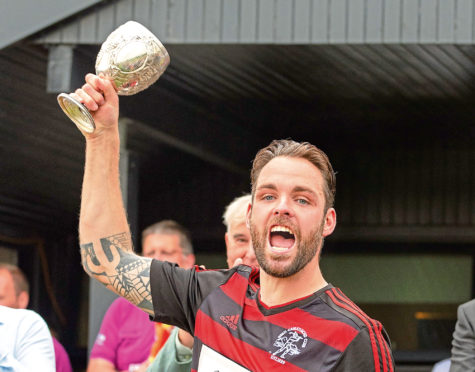 Oban captain Daniel Cameron lifts the Glasgow Celtic Society Cup.