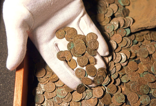 LONDON - NOVEMBER 19:  A man examines  Roman coins found in Snodland, Kent in the British Museum, on November 19, 2008 in London, England. The Roman coin hoard is one the most significant treasure finds of recent years and is being displayed to coincide with the announcement of the Treasure Annual Report.   (Photo by Oli Scarff/Getty Images)