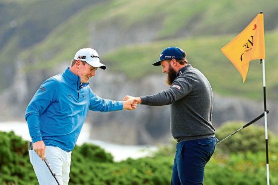 PORTRUSH, NORTHERN IRELAND - JULY 18: Andrew Johnston of England high fives Robert MacIntyre of Scotland on the 5th green during the first round of the 148th Open Championship held on the Dunluce Links at Royal Portrush Golf Club on July 18, 2019 in Portrush, United Kingdom. (Photo by Mike Ehrmann/Getty Images)