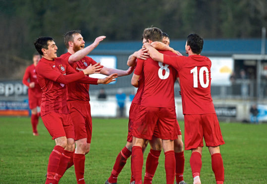 Brora's Martin MacLean celebrating with teammates after scoring