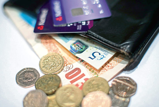 Coins and a five pound and ten pound banknotes and cards in a wallet.