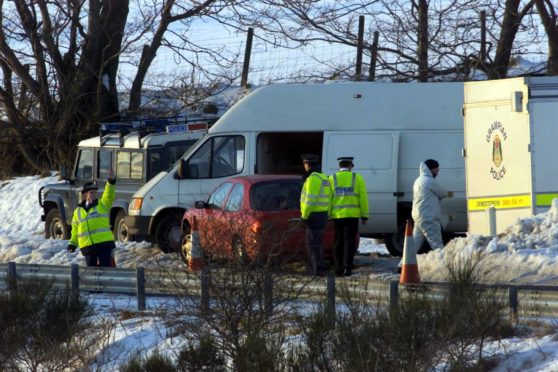 Police near huntly where man's body was found in a lane off the A96 in February 2001