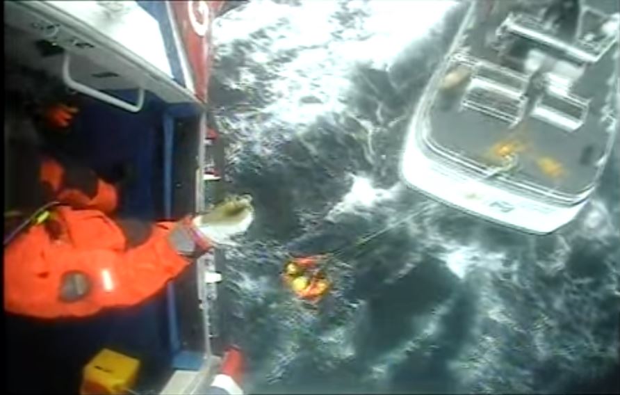 The coastguard winching the fisherman to safety.