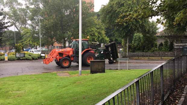 The tractor and its overturned grass cutter on Cairncry road.