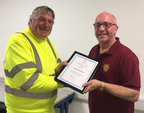 Gordon Lawrence is presented with his award by Scott Strachan of Ellon Rotary Club .