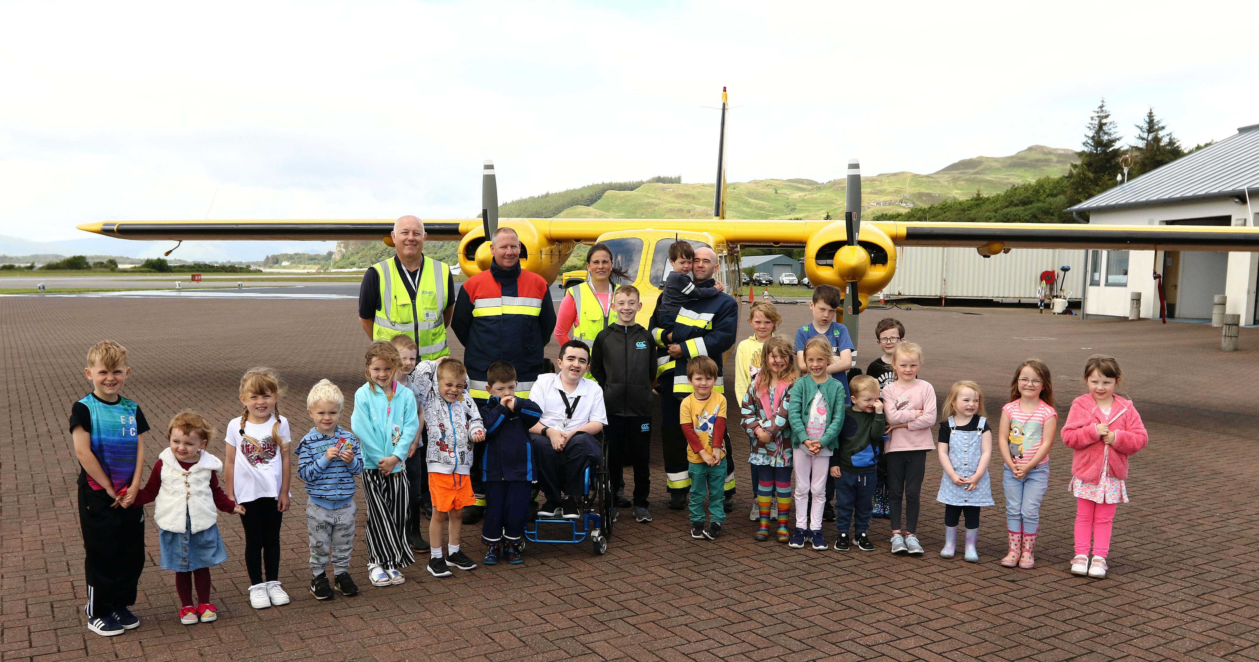 Cameron  Allen (centre chair) with the children and members of Oban Airport Fire crew Tom Eddelston, Murray MacGregor, Katherine Dempster who organised the walk and the refreshment  and paul mackay  who walked the perimeter of Oban Airport to raise funds for Cameron to complete his course picture kevin mcglynn