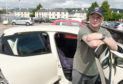 Damian Tucker with his car which was flooded out as it sat in his garage off Strathpeffer Road.