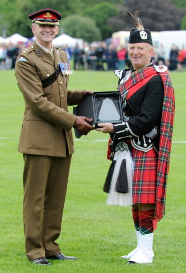 Gordon Straub ,Pipe Major on behalf of the Inverness Royal British Legion Pipe Band is inducted in to the Inverness Highland Games Hall of Fame by Lt Col. Pete Beaumont of 19th Regiment Royal Artillery (Scotland) The Scottish Gunners. Picture by Sandy McCook