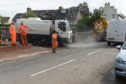 Workmen clearing the remaining water from the roads.