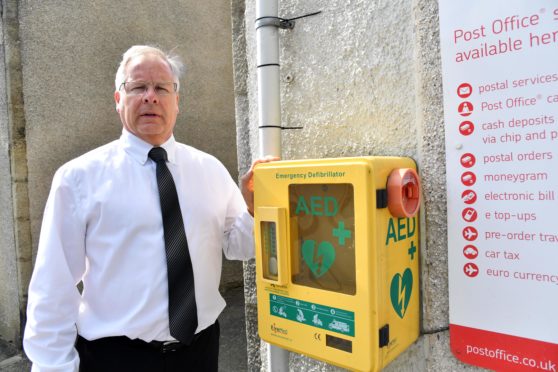 Councillor John Cox beside the defibrillator box in Aberchirder which was vandalised and broken.