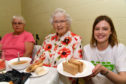 Tanita Addario serves up a plate of sandwiches with Frances Norrie (L) and Ellen Massie at the Big Lunch at the Mustard Seed cafe.