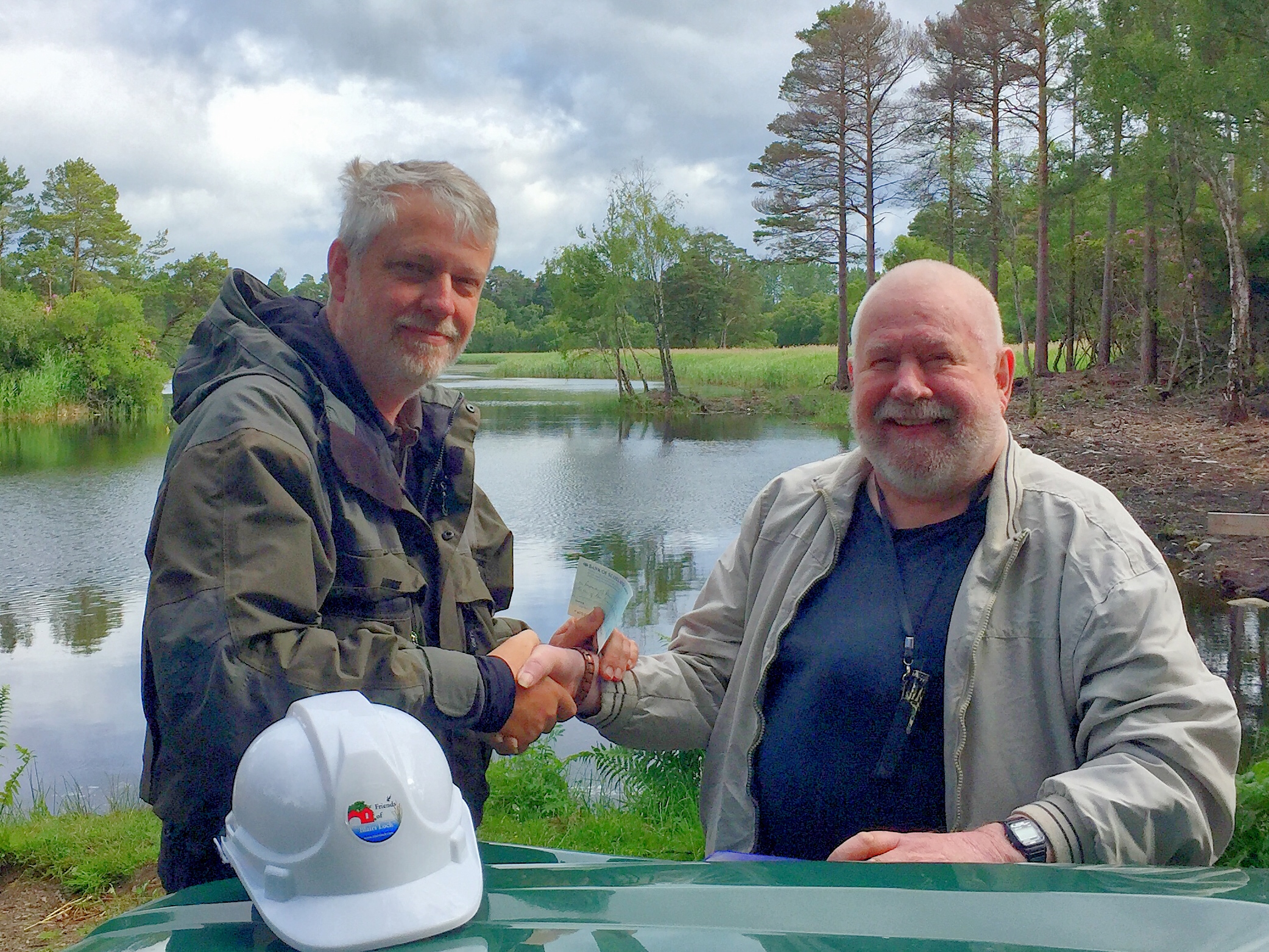 Colin Lipscomb (right) presenting cheque to Friends of Blairs Loch Treasurer, Brian Higgs (left) at Loch of Blairs on the Altyre estate, Forres.