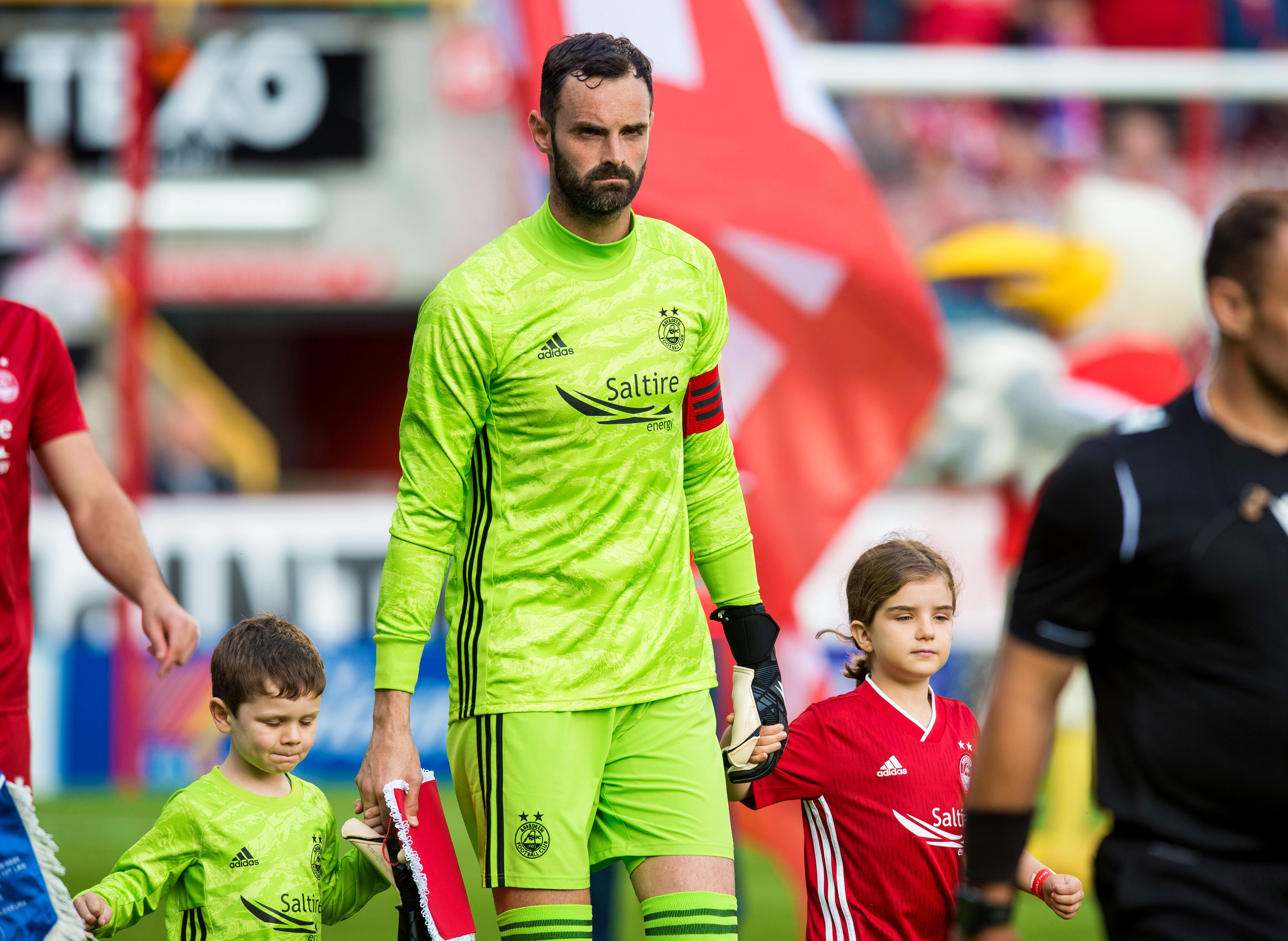 Aberdeen captain Joe Lewis leads his team out onto the field.