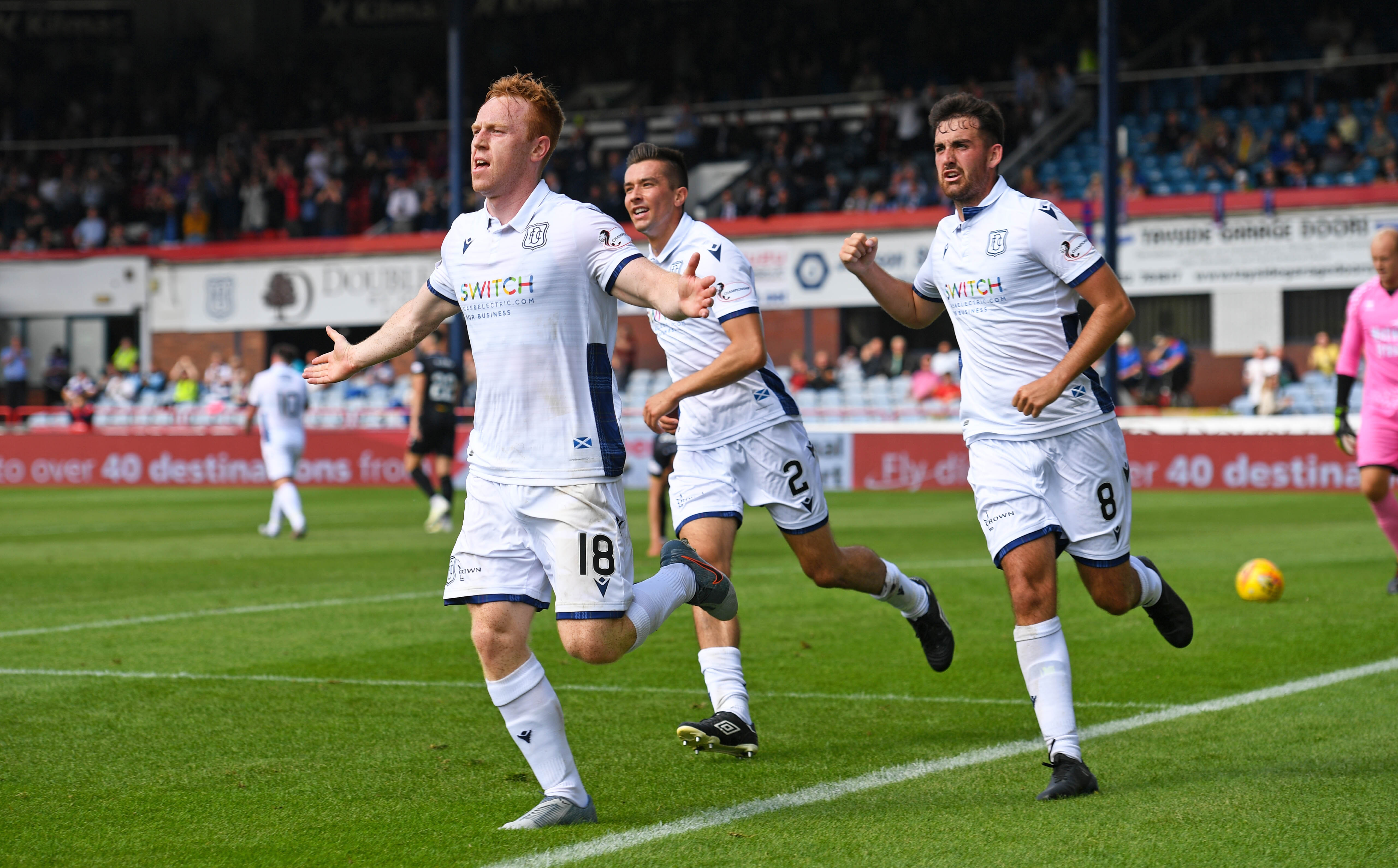 Dundee's Danny Johnson celebrates with teammates Shaun Byrne (R) and Cameron Kerr