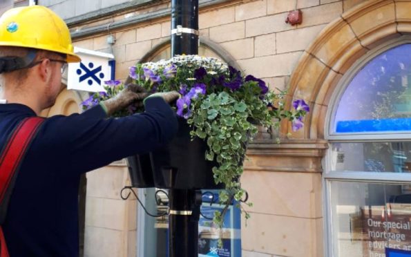 The power firm used lifting equipment to fit the new flower baskets.