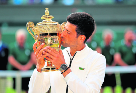 Novak Djokovic with the trophy after beating Roger Federer in the mens singles final on day thirteen of the Wimbledon Championships at the All England Lawn Tennis and Croquet Club, Wimbledon. Photo: Mike Egerton/PA