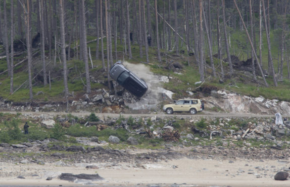 Bond takes to the highland roads with car crash stunt near laggan as the film crew set up with chase stunt cars and crash.