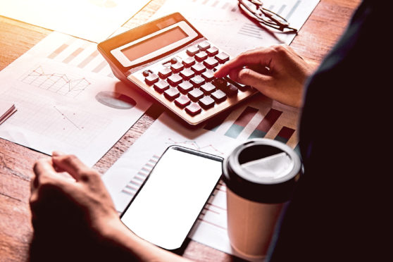 Asian young man in blue shirt holding pen working ,Calculate tax lead to liquidation, With Sunset light vintage style.