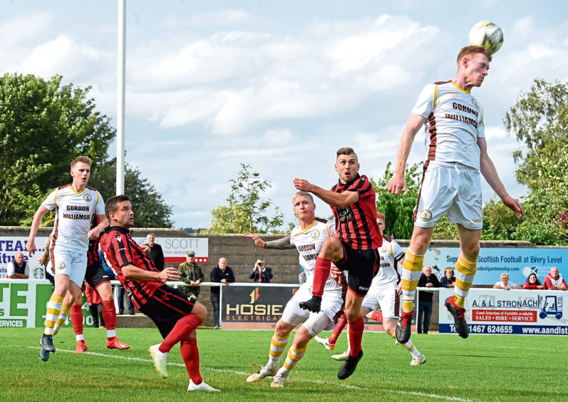 Jordan Milne clears a corner with Neil Gauld, left and Mark Soutar waiting. 
Picture by Jim Irvine