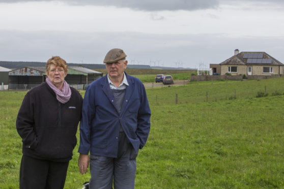 Hamish and Lesley Ritchie outside their home, which is sandwiched between the Ballie and Causewaymire wind farms.