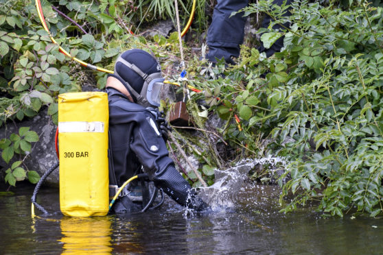 Officers with what is understood to be CCTV recording equipment by the Caledonian Canal.