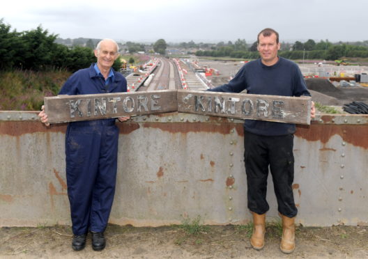 Raymond Sharp and his son Doug Sharp with two original Kintore Railway Station signs prior to their refurbishment