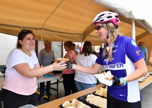 VOLUNTEER ERIN HAY SERVES UP SOUP AND SANDWICHES TO CYCLIST ALLISON MCKENZIE.