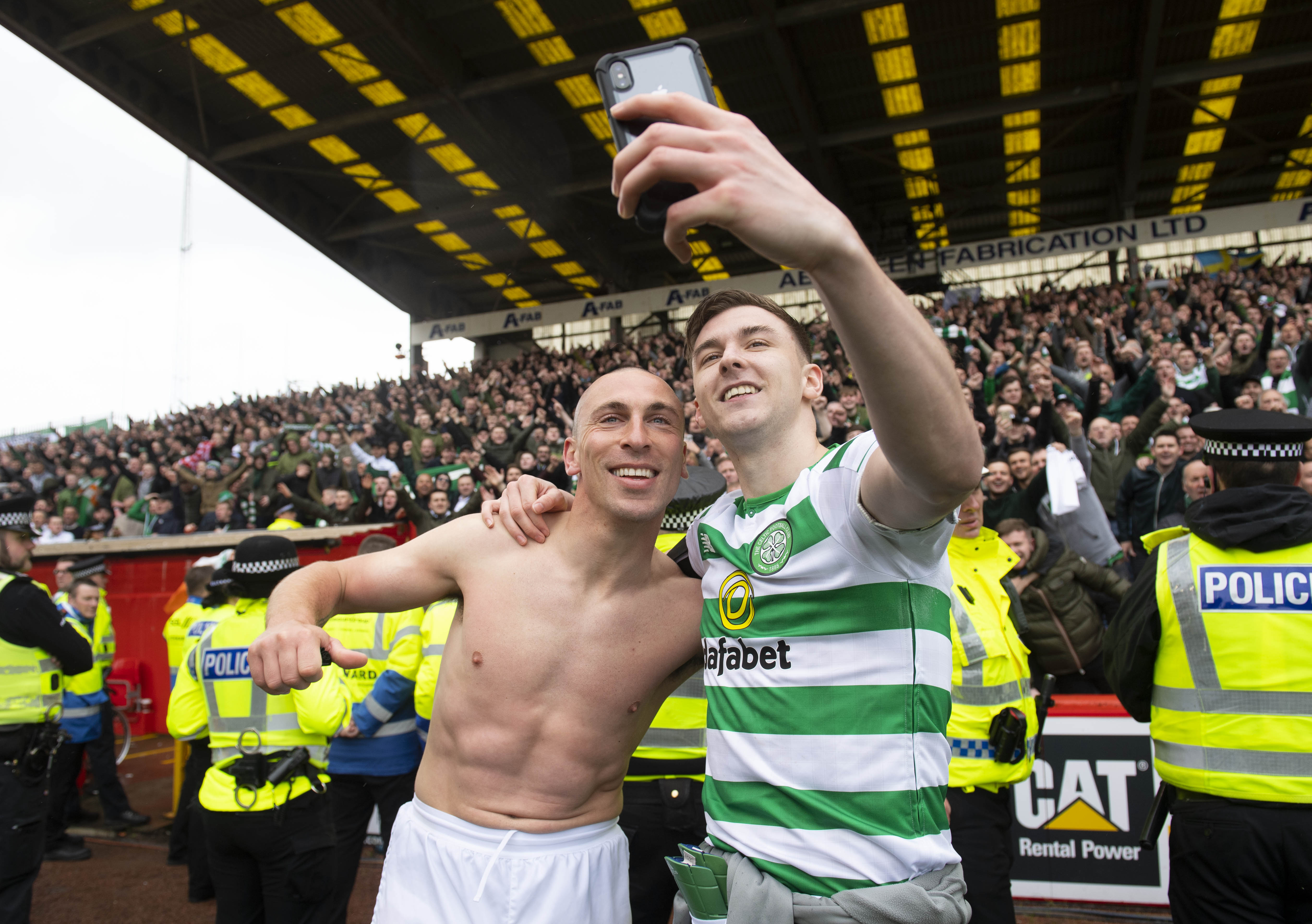 Celtic captain Scott Brown and Kieran Tierney pose for a selfie in front of the fans after clinching the title at last season.