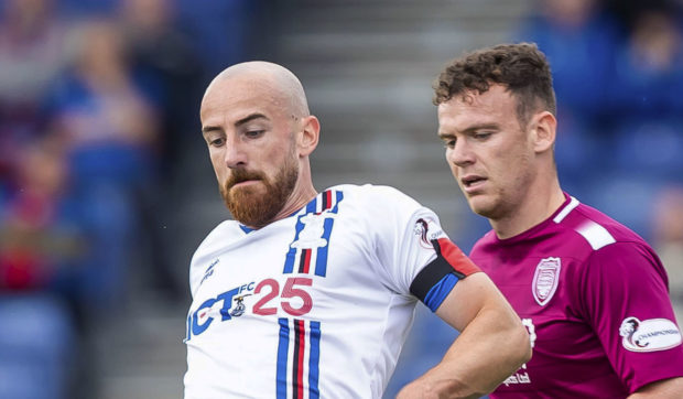 Inverness' James Vincent (L) in action with Arbroath's James Murphy.