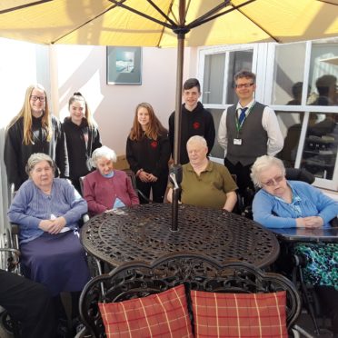 Bayview House residents Jessie Maclean, Ann Miller, Jessan Mackay and Rona Gow are seen here trying out the garden furniture with members of the Thurso High School’s winning team and depute head teacher Mr Omand looking on