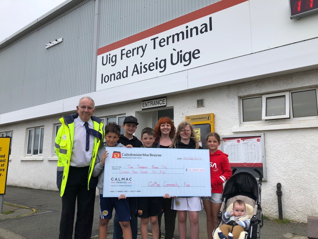 Uig Port Manager, Donald Beaton presents Comann nam Pàrant Port Rìgh with their £2000 cheque.