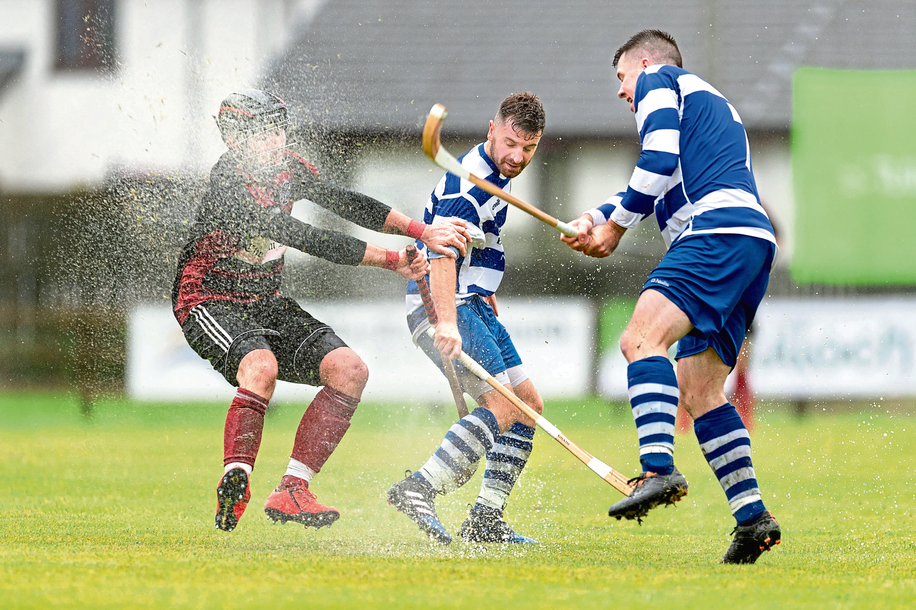 Malcolm Clark (Oban) with Drew and Steven MacDonald (both Nmore). Tulloch Homes Camanachd Cup Final - Newtonmore v Oban Camanachd - played at An Aird, Fort William.