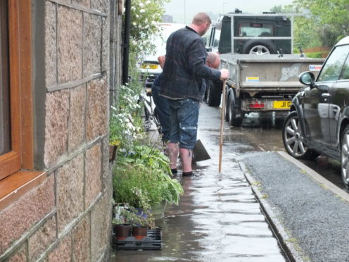 Residents used brooms to clear overflowing drains