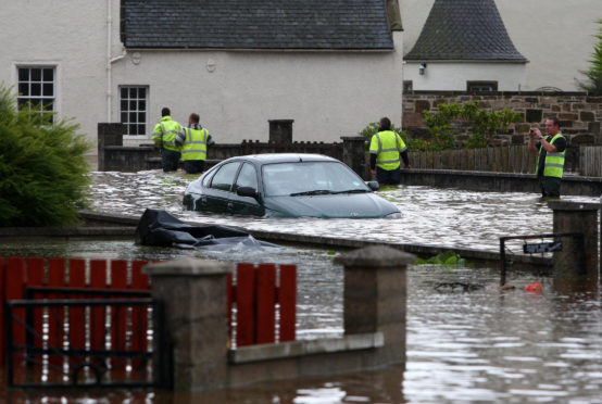 A car is submerged by flood water after the River Lossie burst in banks in Elgin.