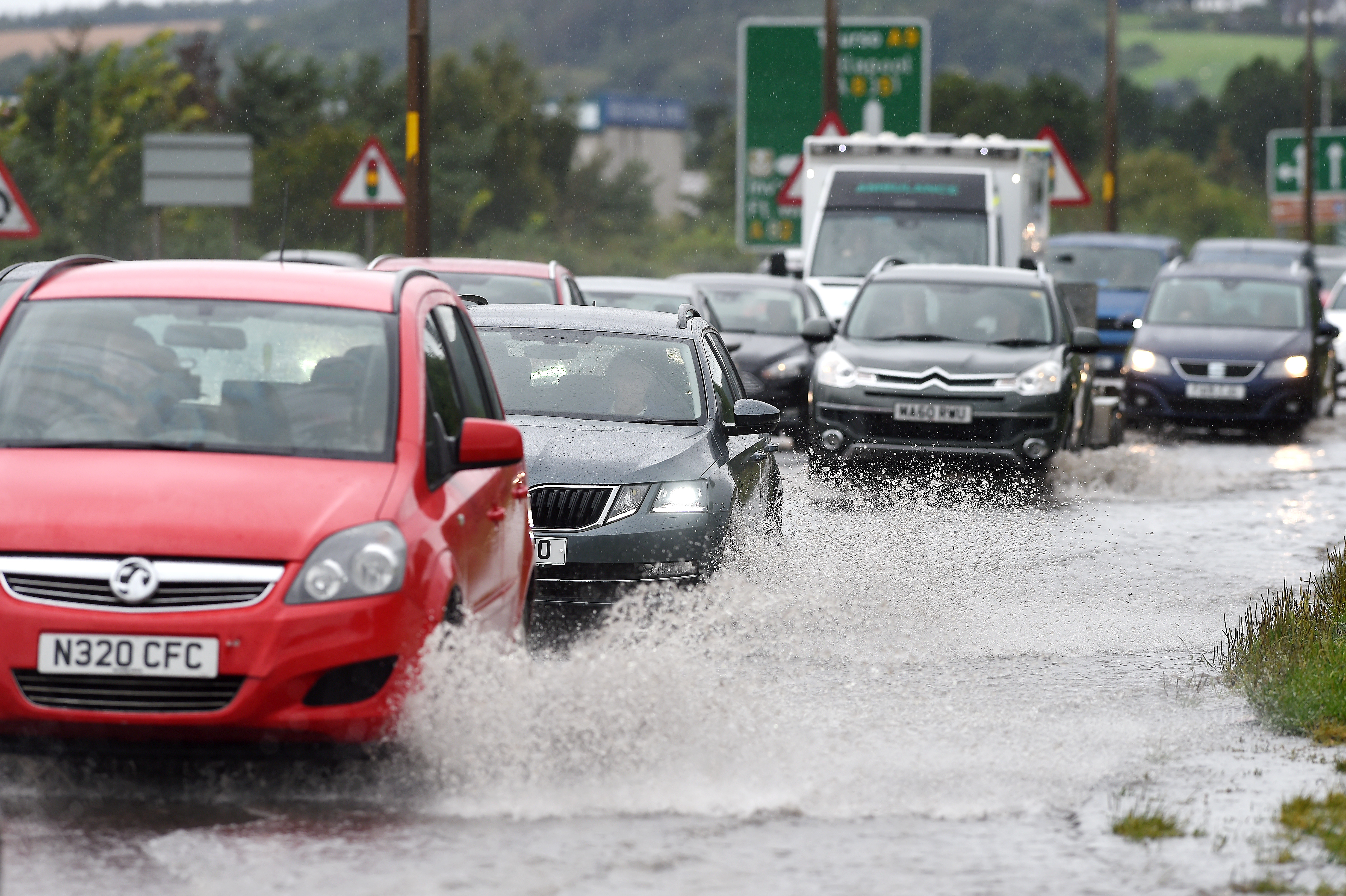 Traffic, including an ambulance has to make its way through deep floodwater on the A9 at Inverness on Saturday morning during torrential rain. Picture and video by Sandy McCook.