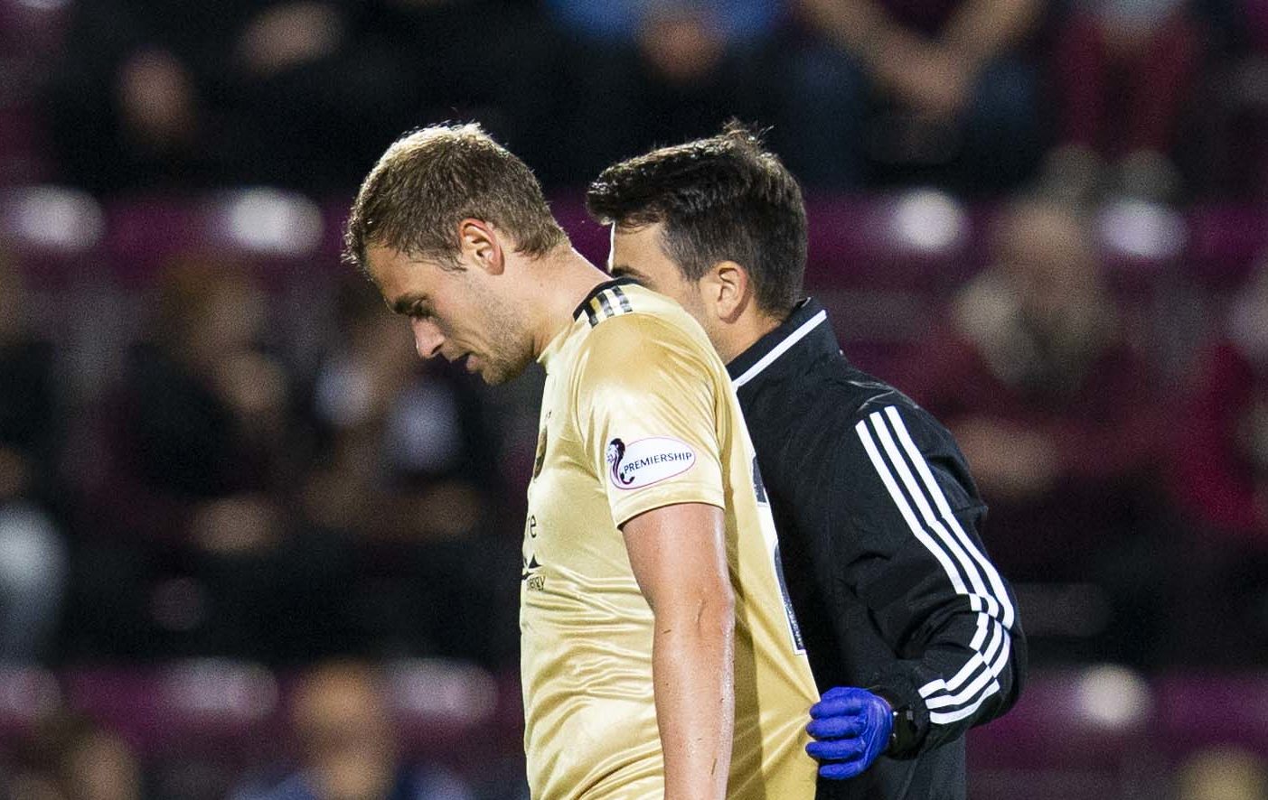 James Wilson is helped off the pitch against Hearts.
