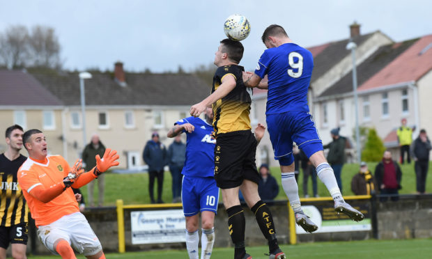 Cove's Mitchel Megginson climbs highest to meet a cross, but his header was wide of goal.