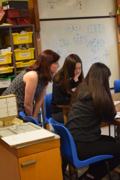 Young women engaging with physics subjects.