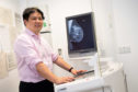 Dr Gerald Lip with digital imaging equipment which is helping to detect more small cancers earlier.