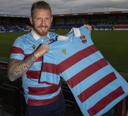 Michael Gardyne unveils Ross County's commemorative 90-year anniversary strip.