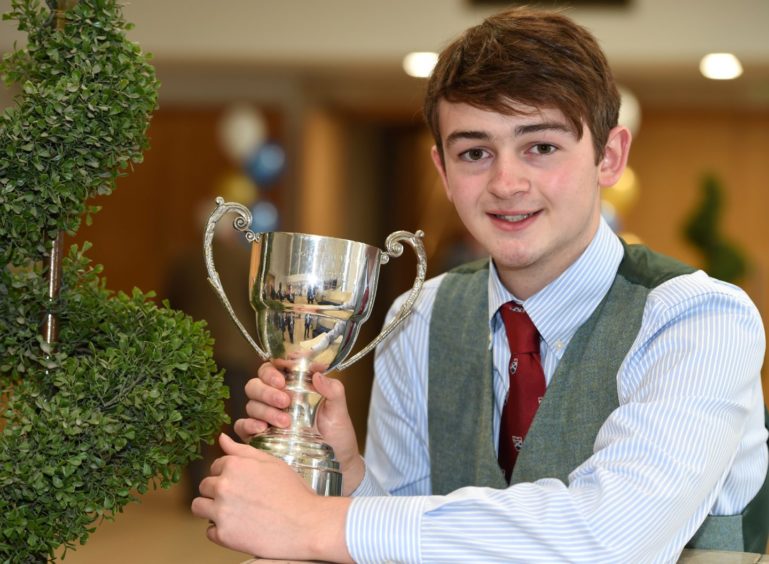 Finlay Cameron of Roy Bridge with the John T MacRae Cup for four part March, Strathspey and Reel in the adult piping competitions. Picture by Sandy McCook