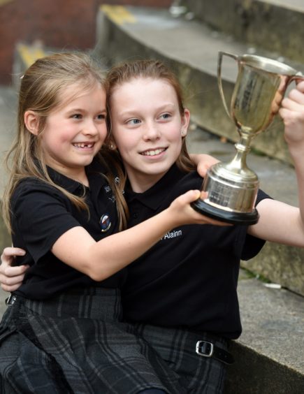 Layla Orr-MacIntyre (12) of the Lochaline Choir (right) with the John Mackenzie Paterson Memorial Trophy for recitation of prescribed poetry while also in the photograph is little sister Kara (7), also a member of the choir and winner of the Hugh Macintyre Memorial Trophy for solo singing in the 7 year old age group. Picture by Sandy McCook.