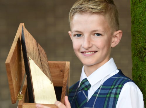 Luke Johnsson of the Sir E Scott School, Tarbert, Harris with the Tom and Rae Mitchell Memorial Trophy for traditional singing in the under 13 category. Picture by Sandy McCook.