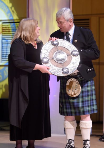 Avril Allan, conductor of Back Gaelic Choir, Lewis accepts the Lorn Shield from Allan Campbell, Chairman of An Comunn Gaidhealach in the Royal Concert Hall, Glasgow. Picture by Sandy McCook.