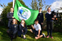 MONQUHITTER PRIMARY SCHOOL ECO COMMITTEE PUPILS (L TO R) KELSEY SUTHERLAND, EMMA WATSON, CONNIE COWIE, ARCHIE CLARK AND CONNOR COWIE RAISE THE GREEN FLAG TO THE SOUNDS OF PIPER AIMEE HOWITT.