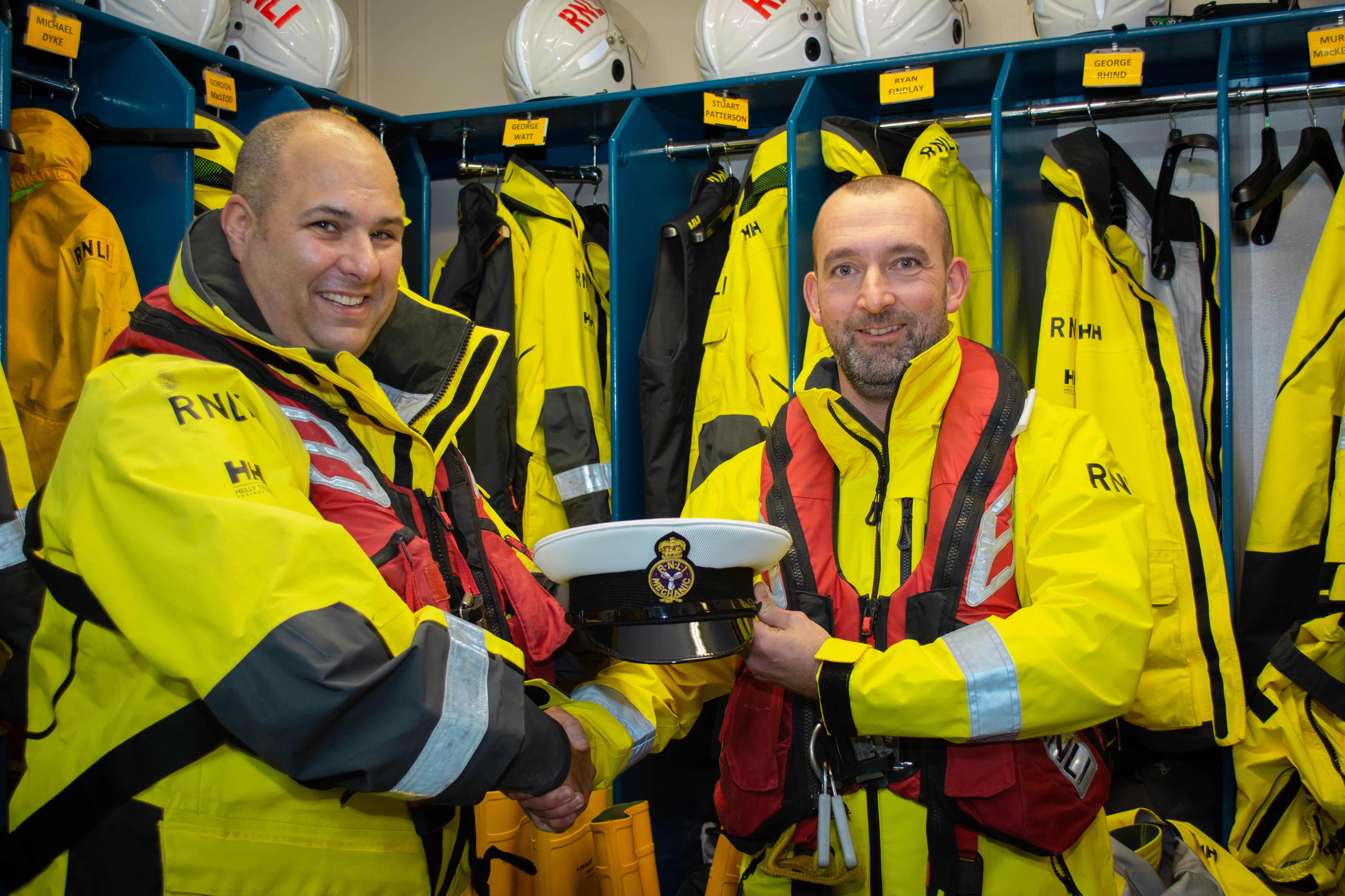 Davie Weir receives his Boat's Officer's hat from Lifeboat operations manager Jurgen Wahle