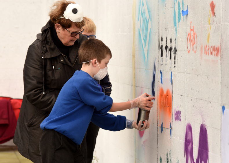 Dorothy Borthwell and Callum Roy painting the wall.