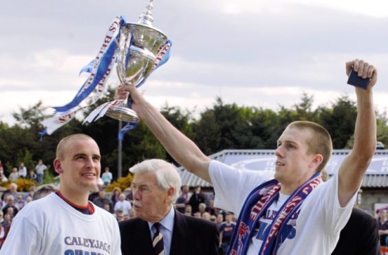 Steven Hislop holds aloft the 2004 First Division title.