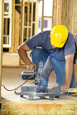 Construction worker cutting wood